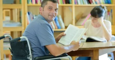 Un hombre con discapacidad, en la biblioteca de una universidad