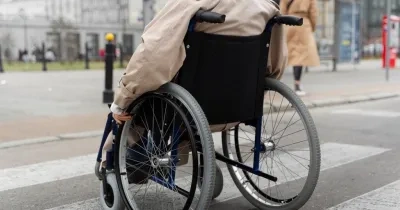 persona en silla de ruedas pasando por un paso de cebra