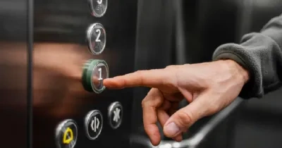 una mano presionando el botón "1" del ascensor
