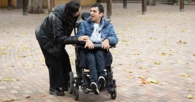 Una persona en silla de ruedas es asistida por otra