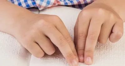 persona leyendo un documento en Braille