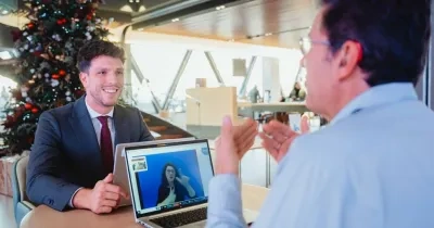 representación de un banquero teniendo una conversación con un cliente con discapacidad auditiva, mediante una interlocución telemática con una intérprete