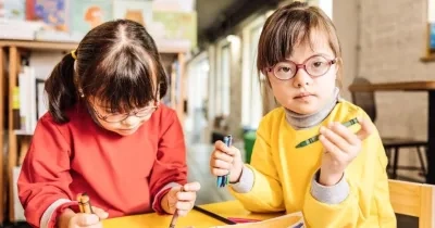 Dos niñas con síndrome de Down dibujan en un aula