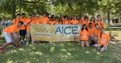 Posado de todos los participantes del campamento, sujetando una bandera con el logo CampAICE
