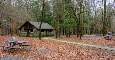 una casa rural independiente, a la que se accede por un sendero de madera, facilitando su accesibilidad a sillas de ruedas. También aparece un bosque de fondo y un merendero para sentarse a comer al aire libre.