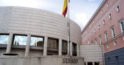 Fachada principal del Senado con una bandera de España en todo lo alto