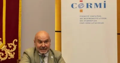 El presidente del CERMI, Luis Cayo, durante una conferencia de prensa. Arriba a la derecha sale el logo del CERMI