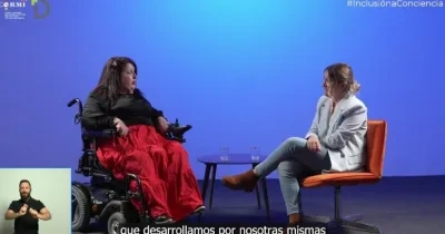 do mujeres hablando en un escenario sobre la discapacidad y la mujer, abajo a la izquierda se sitúa un intérprete y hay subtitulado también sobre lo que van hablando