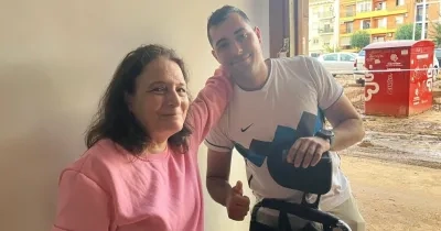 Voluntario de Cocemfe CV ayuda a una señora damnificada por la DANA