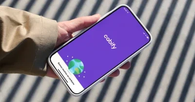 mano agarrando un móvil con la app de Cabify abierta en la pantalla