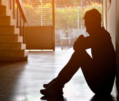 Una persona joven sentada en el suelo con depresión (Fuente: SHUTTERSTOCK)
