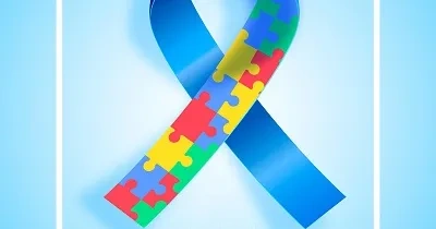 cartel con un lazo azul y construido por piezas de colores que simbolizan el día mundial de la concienciación del autismo en inglés
