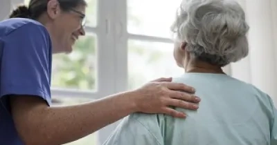 Una enfermera atendiendo a una anciana (Fuente: Servimedia)