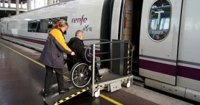 Una persona en silla de ruedas accediendo a un AVE por una rampa con ayuda del personal (Fuente: Servimedia)