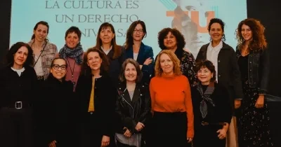 Mujeres y madres reivindicadoras en un escenario con una pantalla digital de fondo