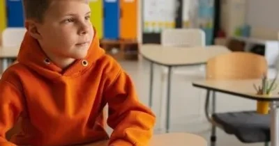 niño en un colegio sentado en el pupitre