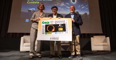 Los representantes sujetando el cupón gigante por el día conmemorativo