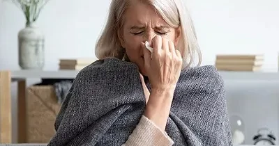 Una persona mayor con síntomas de gripe o resfriado (Fuente: Oticon)