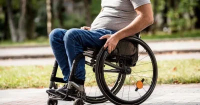 Un hombre en silla de ruedas cerca de un parque