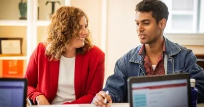 Dos personas conversan en una oficina