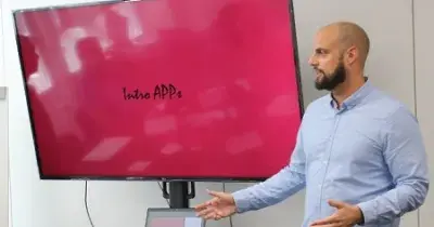 un hombre junto a una pantalla dando una formación