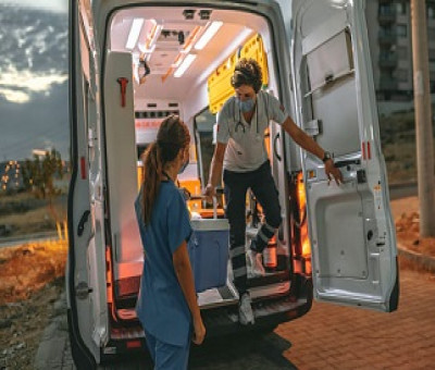 Dos sanitarias bajando de una ambulancia, trasportando una nevera con una donación de un órgano