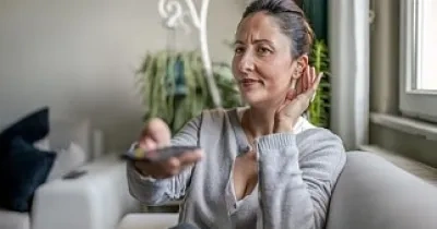 Mujer viendo la tv con audífonos