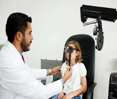 Doctor revisando a una niña los ojos