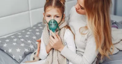 madre poninedo mascarilla de inhalacion a su hija