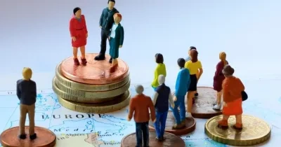 Muñecos subidos a monedas en una representación de la economía social