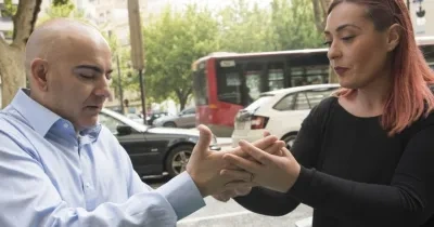 Una mediadora interactúa con un hombre de mediana edad sordociego