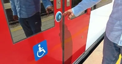 puerta accesible de un metro con un hombre preparado para pulsar el pulsador accesible para abrir la puerta