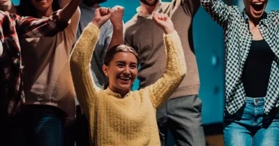 mujer con discapacidad celebrando un logro junto a más personas