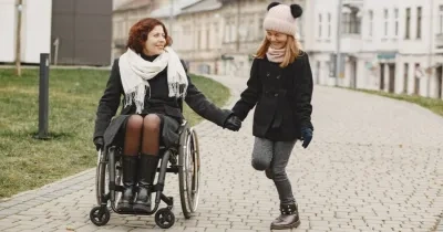 mujer con silla de ruedas junto a su hija