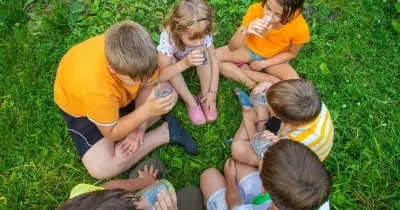 Seis niños sentados en el césped en corrillo