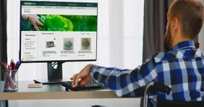 Un hombre usuario de silla de ruedas navega por la nueva página web de compra online de Eroski