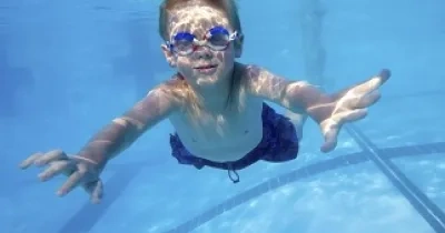 Un niño nadando debajo del agua de una piscina (Fuente: Clínica Baviera)