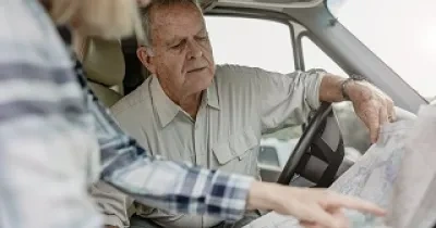 pareja de tercera edad mirando un mapa antes de conducir
