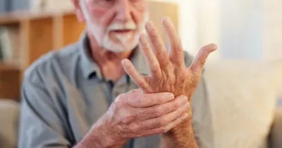 Señor mayor tocándose la mano