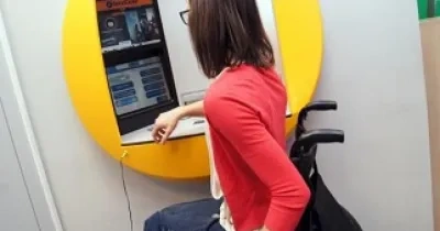Una mujer en silla de ruedas utilizando un cajero (Fuente: Servimedia)