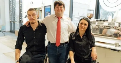 tres personas con discapacidad en una cafetería posando para una foto