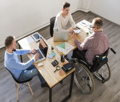 Tres personas trabajando juntas, una de ellas en silla de ruedas (Fuente: Servimedia)