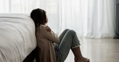 Una mujer con depresión, sentada en el suelo de su casa (Fuente: Servimedia)