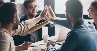 Grupo de jóvenes trabajando juntos y chocando sus manos (Fuente: Fundación Integra)