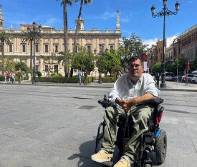 Carlos Reina Rosales, de 35 años y uno de los participantes en este estudio, sentado en su silla de ruedas eléctrica, frente a un museo en el centro de Sevilla (Fuente: Jonas Bull/Human Rights Watch)