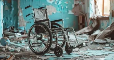 una silla de ruedas en medio de una habitación de una casa derruida