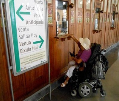 Una mujer usuaria de silla de ruedas adquiere un billete en las taquillas de la Estación del Norte de Valencia (Fuente: Cocemfecv)