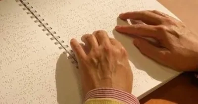 Detalle de una persona leyendo en braille