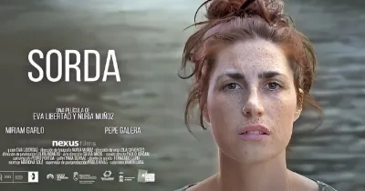 Cartel de la película 'Sorda' donde se ve el título, una mujer pelirroja en la portada y de fondo un mar. Acompañado de los nombres de actores participantes y os logos de los patrocinadores
