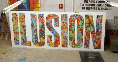aparece un cartel dentro de la imagen con la palabra "ilusion" coloreada con diferentes colores